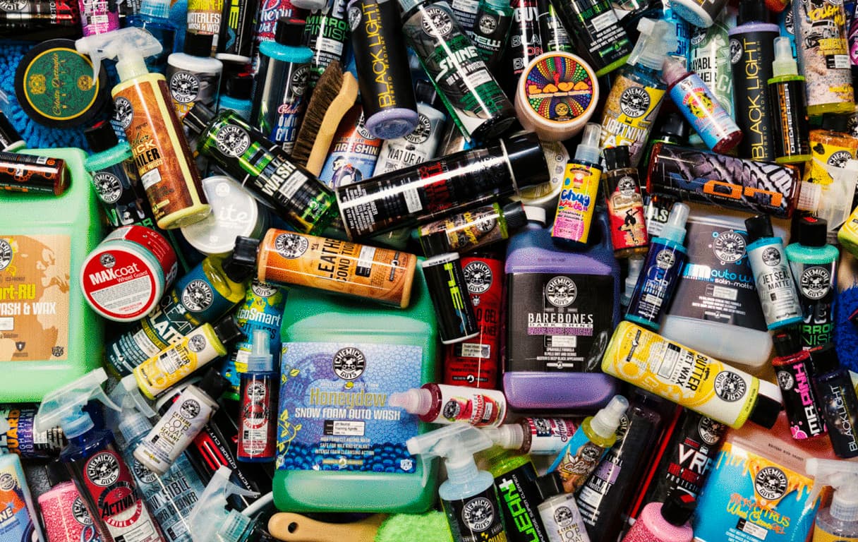 A wide variety of Chemical Guys product bottles, brushes, and accessories laid out together