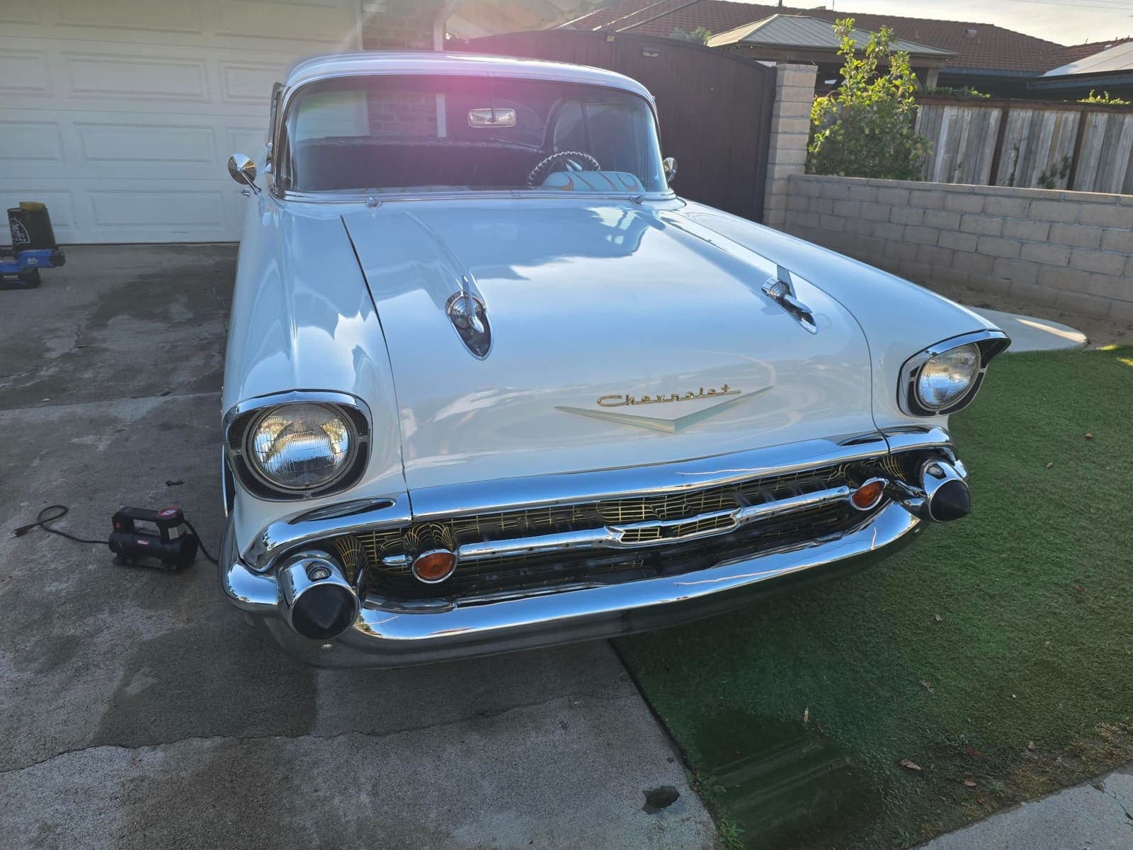 Head-on view of a 1957 Chevy Bel Air's chrome grille and Chevrolet hood emblem