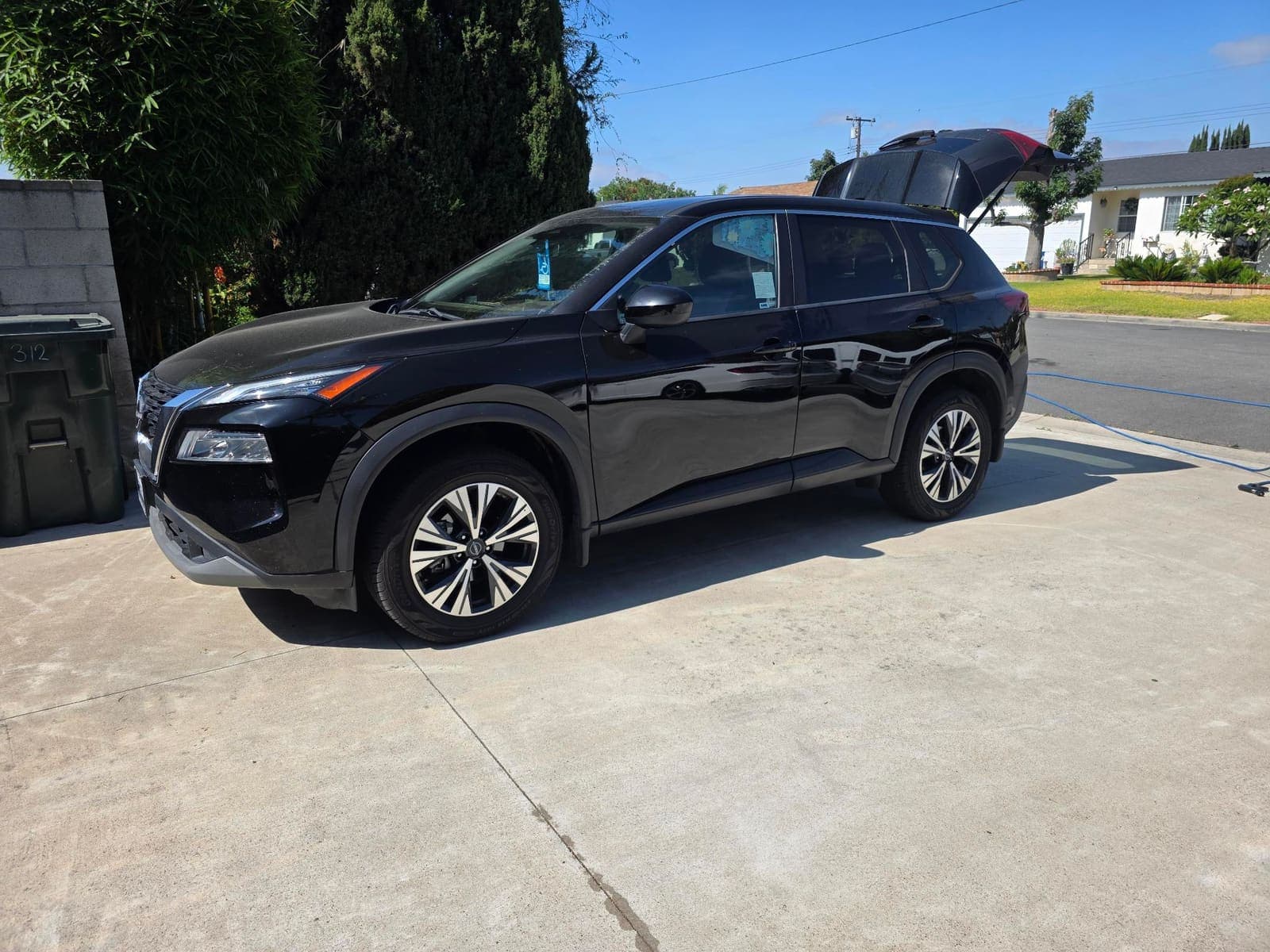 Black Nissan Rogue side profile, glossy paint after a wash