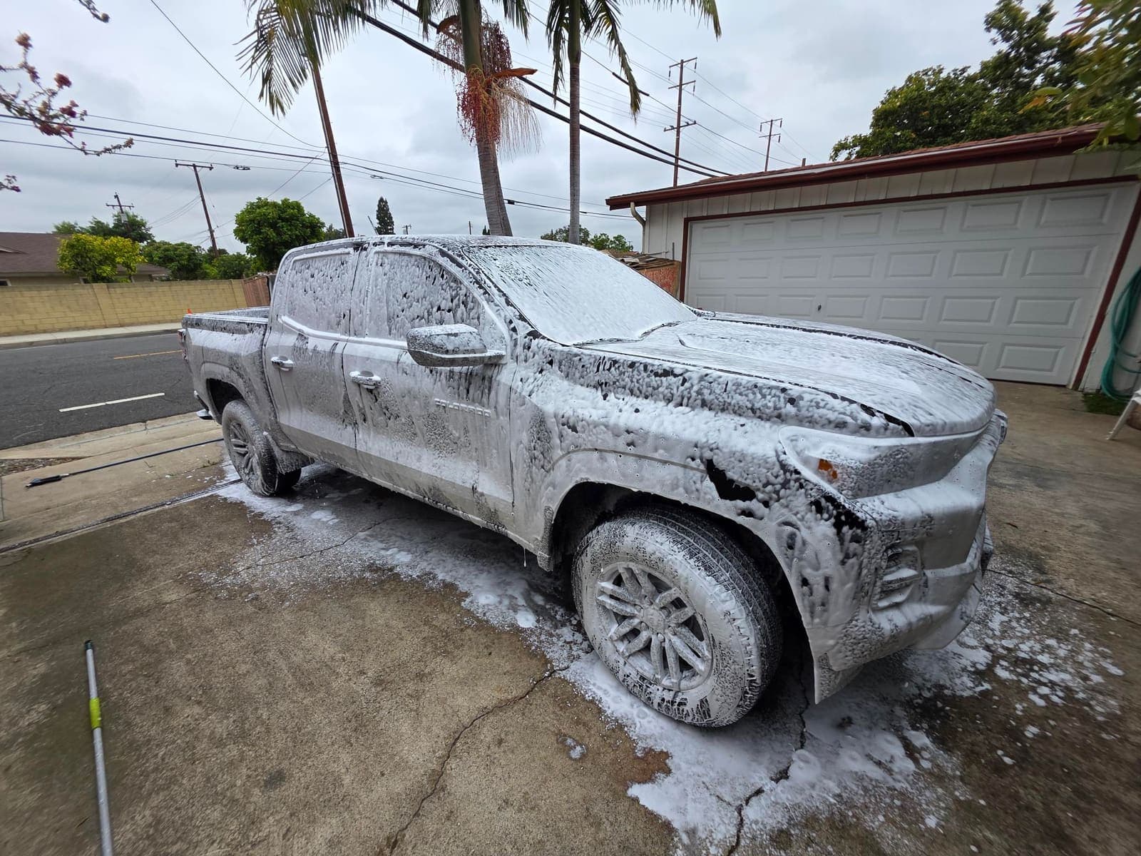 Chevy Colorado blanketed in snow foam, mid-wash