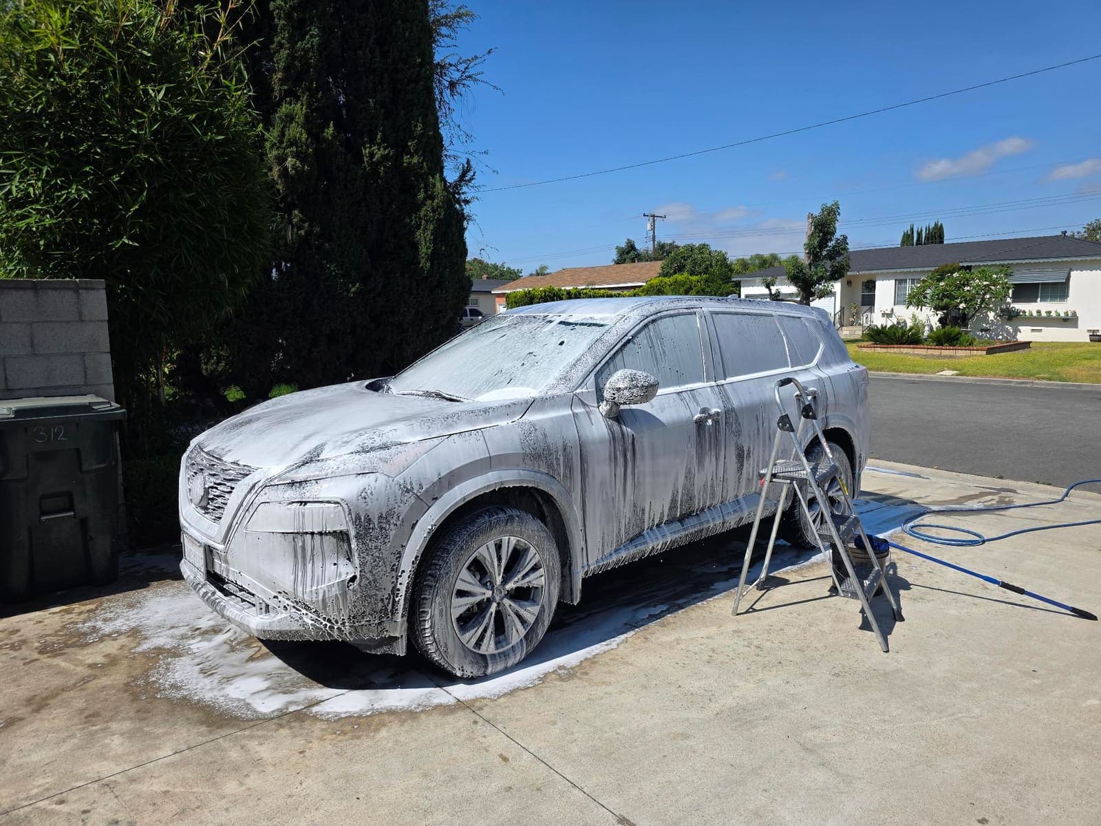 White Nissan Rogue covered in foam during the wash process