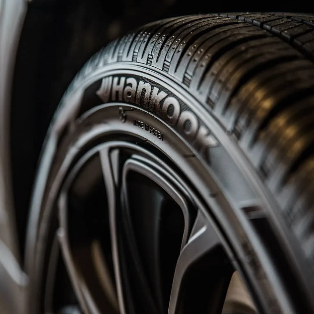 Freshly dressed tire with a deep satin shine on a dark alloy wheel